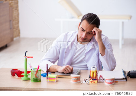 Young male dentist working in the clinic Young male dentist working in the clinic 76045983