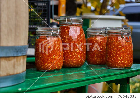 Canning the hot pepper. Glass jars with hot pepper. Hot sauce in jars 76046033