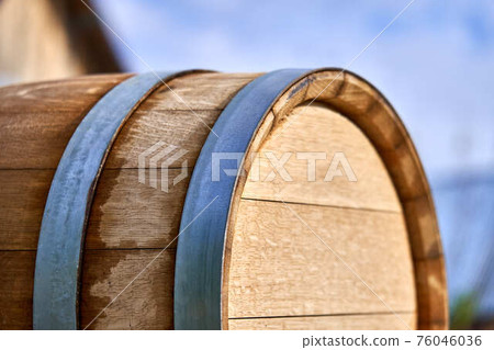 Oak barrel for storage wine lies on special support in yard Oak barrel for storage wine lies on special support in yard 76046036