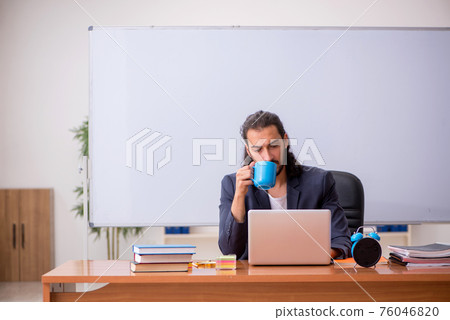 Young male teacher in the classroom 76046820