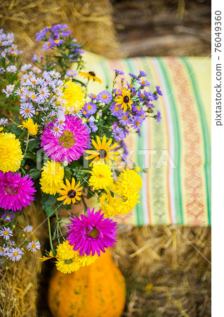 Autumn still life. bright autumn bouquet of flowers in a jug 76049360