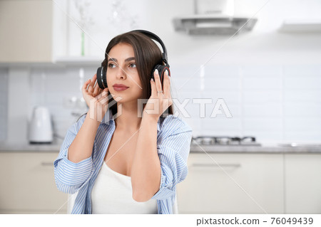 Young woman listening music in headphone. 76049439