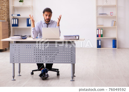 Young male employee working in the office Young male employee working in the office 76049592