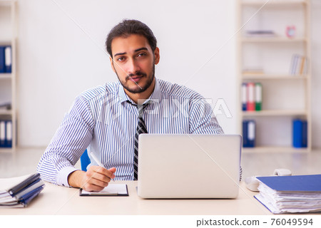 Young male employee working in the office Young male employee working in the office 76049594