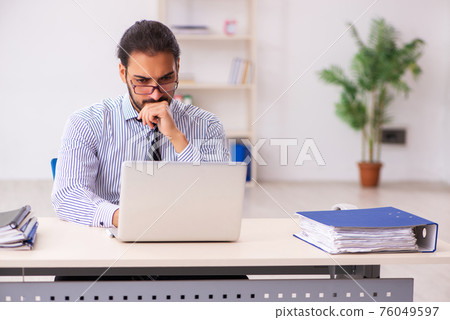 Young male employee working in the office 76049597