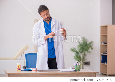 Young male dentist lecturer working in the clinic 76049600