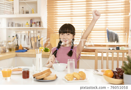 Asian child happy eating breakfast in kitchen room at home. Asian child happy eating breakfast in kitchen room at home. 76051058