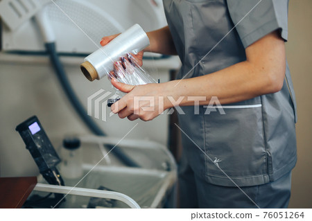 woman prepare instruments for permanent makeup to work use wrap tape for sterility, tools for tattoo ready to use woman prepare instruments for permanent makeup to work use wrap tape for sterility, tools for tattoo ready to use 76051264