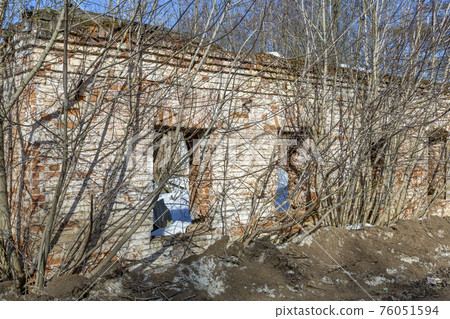 Part of the old facade of an abandoned stone house Part of the old facade of an abandoned stone house 76051594