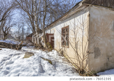 Part of the old facade of an abandoned stone house Part of the old facade of an abandoned stone house 76051595
