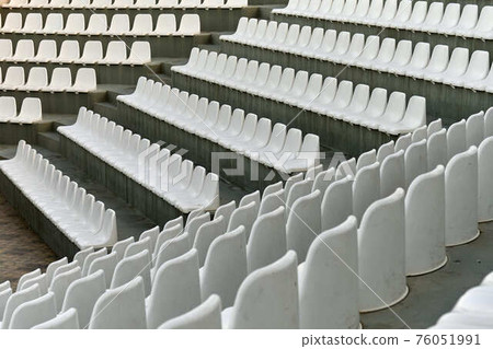 Chairs made of white plastic on spectator places of stadium Chairs made of white plastic on spectator places of stadium 76051991