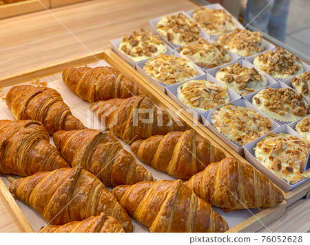 Fresh and puffy croissants and creamy cheese tarts in bakeshop Fresh and puffy croissants and creamy cheese tarts in bakeshop 76052628