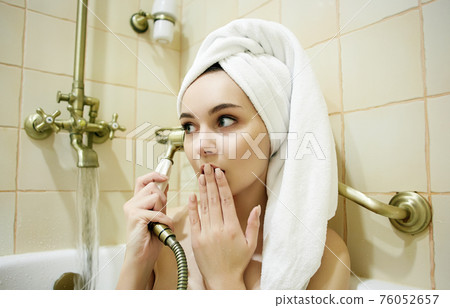 Funny girl in towel. talking on the phone in bathtub 76052657