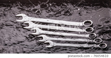 Wrenches of different sizes on a dark background 76054610