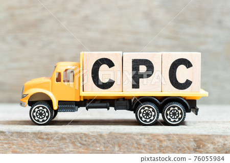 Toy truck hold alphabet letter block in word CPC (Abbreviation of Cost per click) on wood background 76055984