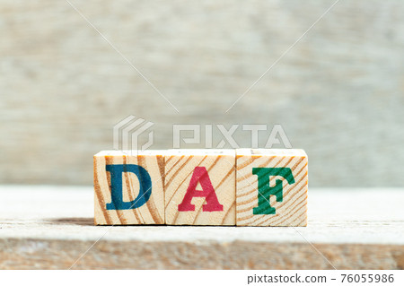 Alphabet letter block in word DAF (Abbreviation of Delivered at frontier) on wood background 76055986