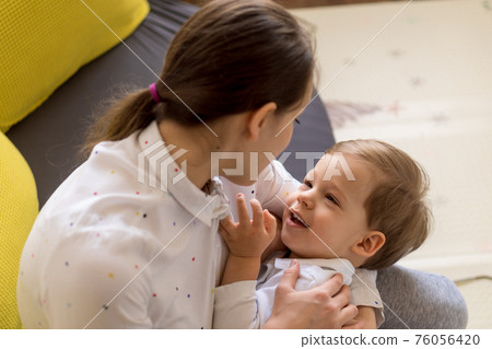 caucasian family little preschool baby boy and mom young woman hug joyfully together in living room at home with happiness smile. Child son congratulates on Mother's Day. Motherhood, childhood concept caucasian family little preschool baby boy and mom young woman hug joyfully together in living room at home with happiness smile. Child son congratulates on Mother's Day. Motherhood, childhood concept 76056420
