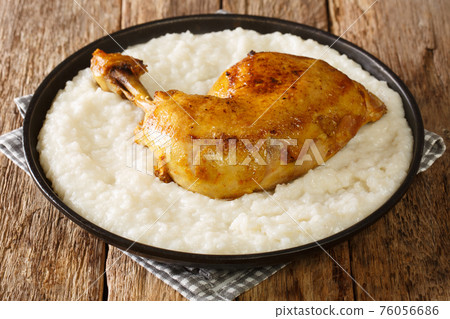 Delicious rice cooked in broth with milk and butter, and chicken quarters close-up on a plate. horizontal 76056686