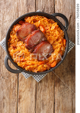 Serbian Baked Sauerkraut Podvarak with smoked pork and bacon closeup in the pan. Vertical top view 76056699