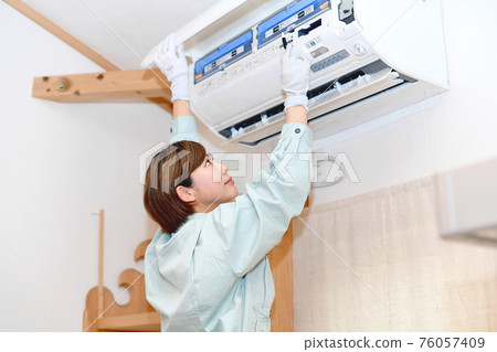 Workers checking the air conditioner 76057409