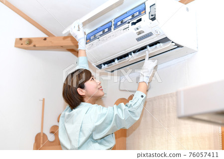 Workers checking the air conditioner 76057411