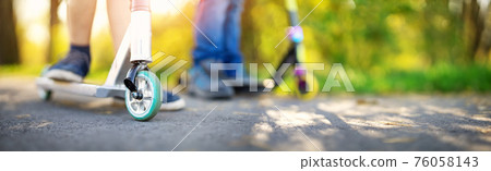 Boyfriends riding on bicycles on asphalt road in summer. 76058143