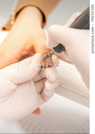 Manicurist removing old nail polish Manicurist removing old nail polish 76058166