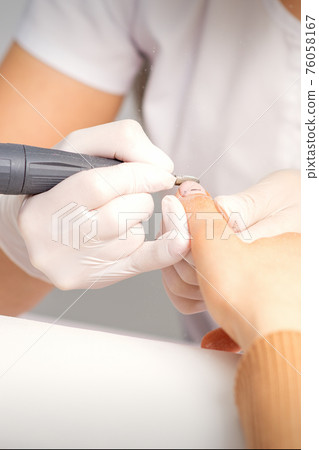 Manicurist removing old nail polish 76058167