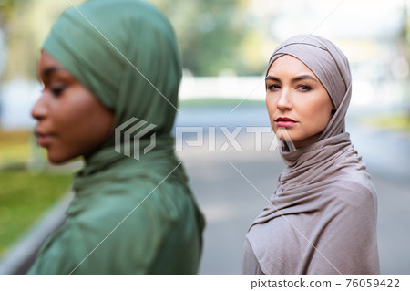 Two Diverse Muslim Women Posing Outdoors, Wearing Traditional Hijab 76059422