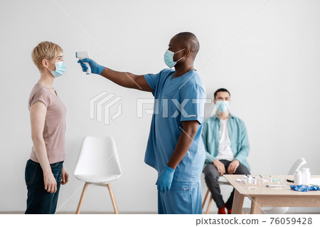 Medical staff caring for patient, check first symptoms of covid-19 virus and preparing for population vaccination 76059428