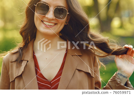Stylish woman spending time in a spring park 76059971