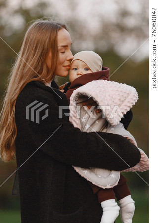 Cute and stylish family in a autumn park 76060042