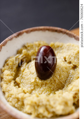 A bowl of creamy hummus with olive oil A bowl of creamy hummus with olive oil 76060624