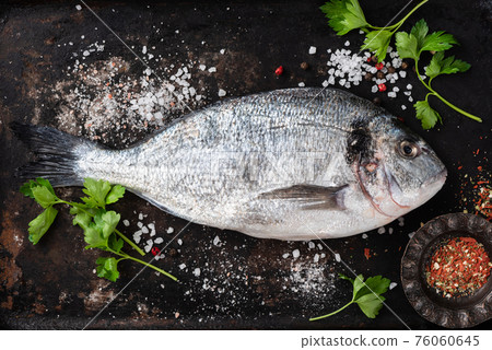 Fresh dorado with spices on black background Fresh dorado with spices on black background 76060645