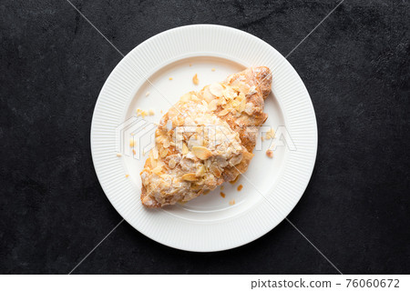 Sweet almond croissant on white plate 76060672