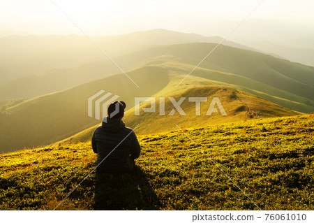 Alone tourist on the edge of the mountain hill 76061010