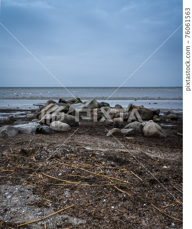 Boulders at Lomma Beach, Malmo, Sweden. Blue sky and ocean in the background 76061563