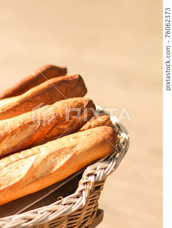 Bread baguettes in basket at baking shop on a sunny day 76062373