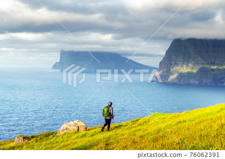 Lonely tourist looks at foggy islands 76062391