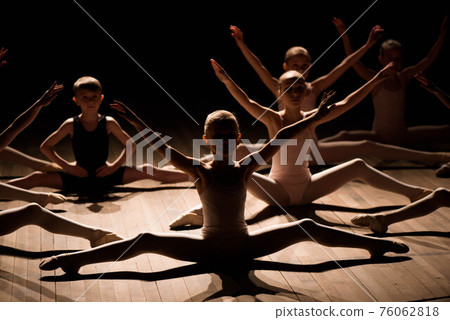 Pretty young girl and boy sitting on stage having stretching and training for ballet dances 76062818