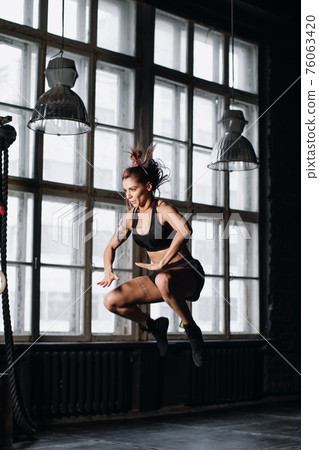 Young girl doing sports in the gym. Atmospheric gym 76063420