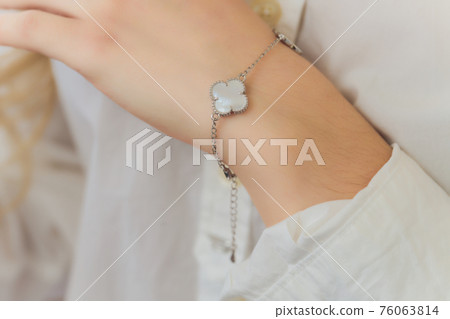 Woman's hands with perfect manicure with silver bracelet. 76063814