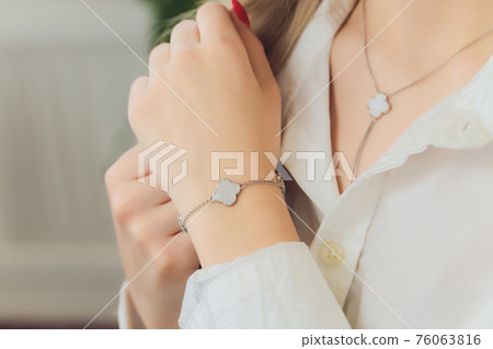 Woman's hands with perfect manicure with silver bracelet. 76063816