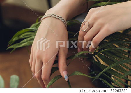 Woman's hands with perfect manicure with silver bracelet. 76063851