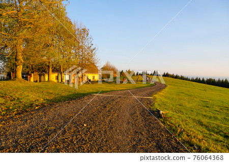 Autumn landscape and country road at sunset time 76064368