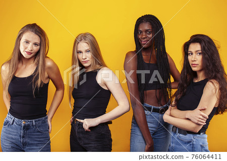 diverse multi nation girls group, teenage friends company cheerful having fun, happy smiling, cute posing on yellow background, lifestyle people concept, african-american, asian and caucasian diverse multi nation girls group, teenage friends company cheerful having fun, happy smiling, cute posing on yellow background, lifestyle people concept, african-american, asian and caucasian 76064411