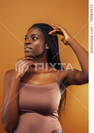 pretty young african american woman with braids posing cheerful gesturing on brown background, lifestyle people concept pretty young african american woman with braids posing cheerful gesturing on brown background, lifestyle people concept 76064415