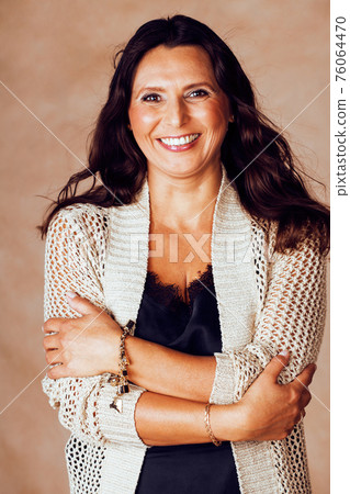 mature brunette real middle age woman well dressed posing smiling on warm brown background, aging concept, modern fashion dress close up mature brunette real middle age woman well dressed posing smiling on warm brown background, aging concept, modern fashion dress close up 76064470