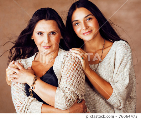cute pretty teen daughter with mature mother hugging, fashion style brunette concept cute pretty teen daughter with mature mother hugging, fashion style brunette concept 76064472