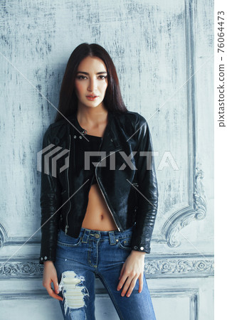 young brunette woman in leather jacket at vintage wall young brunette woman in leather jacket at vintage wall 76064473